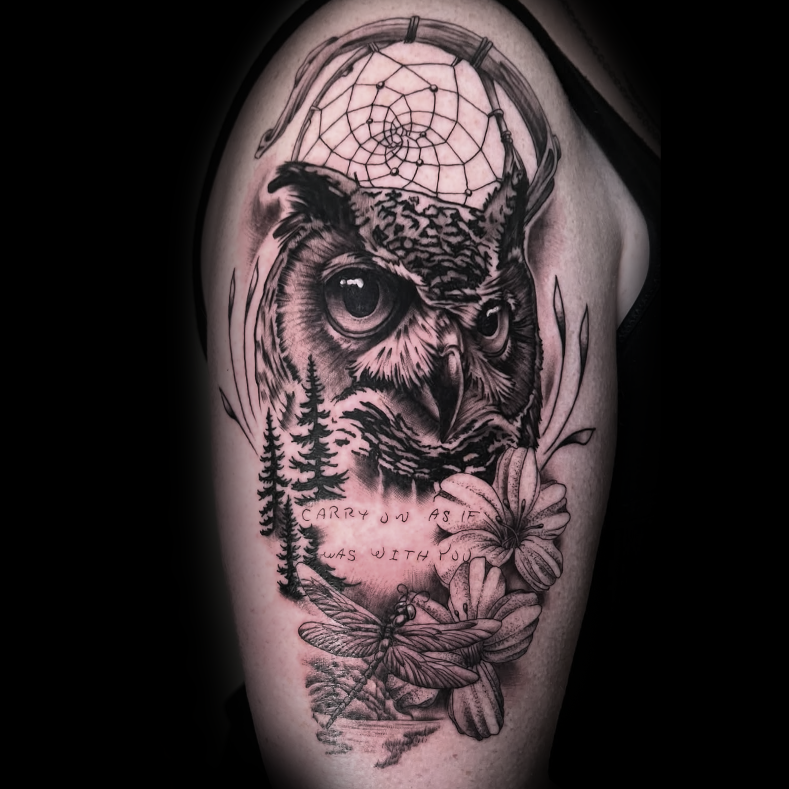 Detailed tattoo of an owl with a dreamcatcher, flowers, and a dragonfly on a person's arm with script tattoo by Dominic, tattoo artist at Sundog Studios in Airdrie Alberta