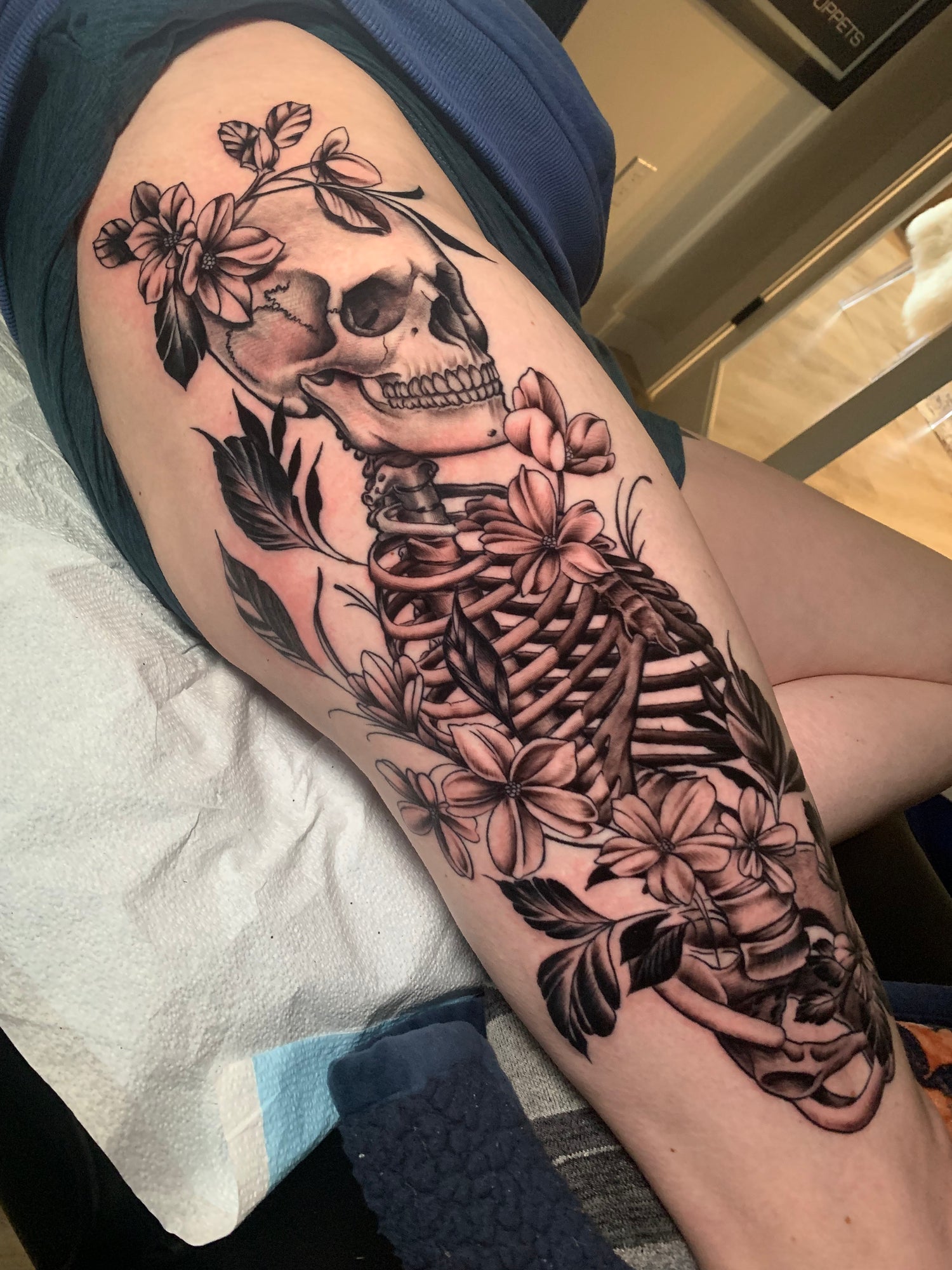 Black and grey skeleton and floral upper leg tattoo by tattoo artist Dom at Sundog Studios in Airdrie, Alberta