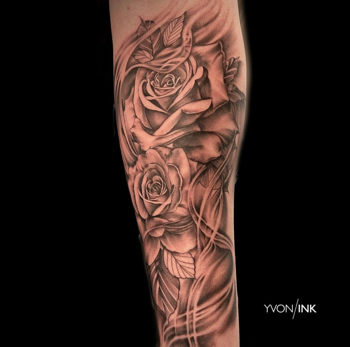 Black and grey rose and leaves forearm tattoo with flowing ornamental design by Yvon Ink at Sundog Studios in Airdrie, Alberta