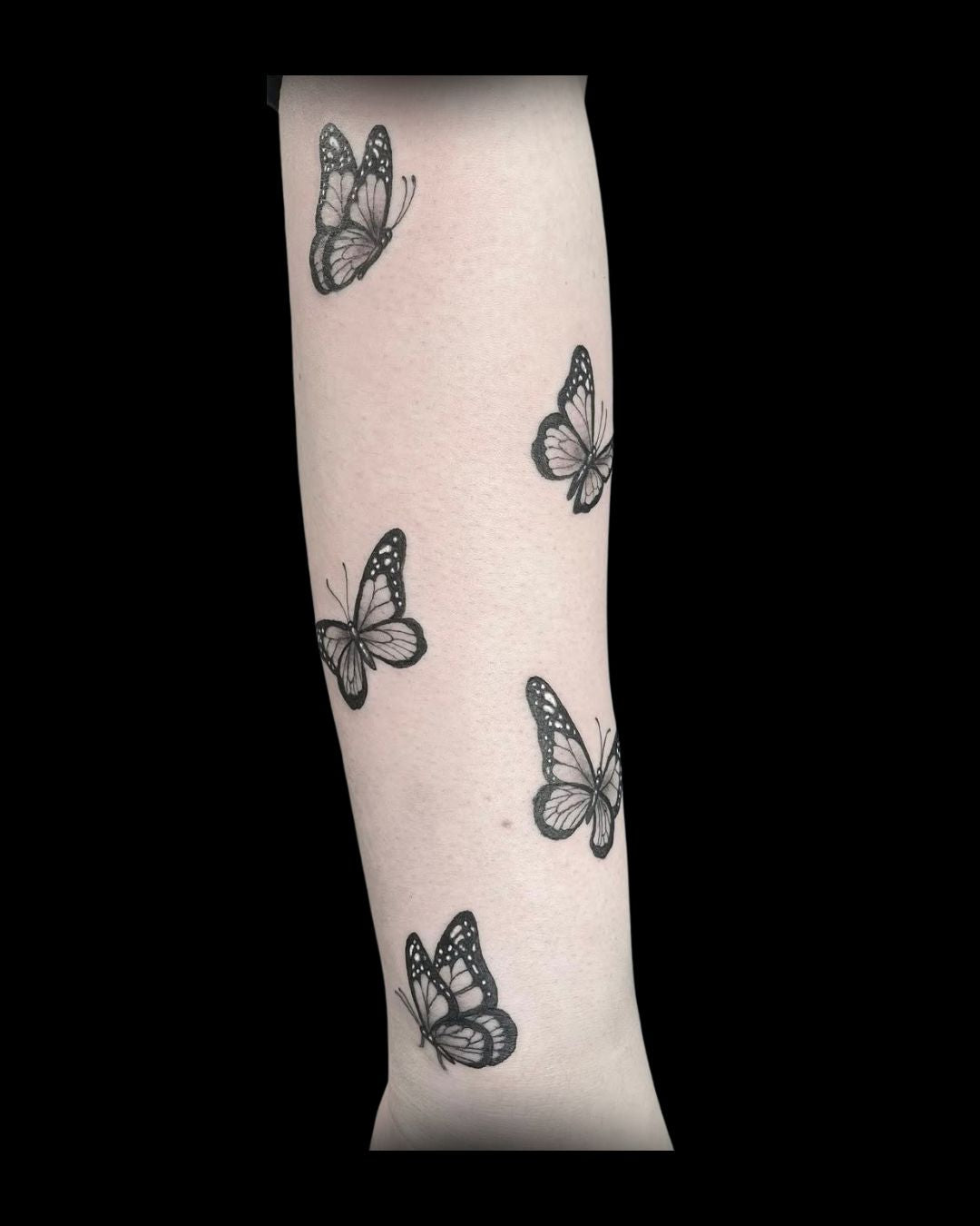 black butterfly tattoos of a person's arm by Mahala, tattoo artist at Sundog Studios in Airdrie Alberta