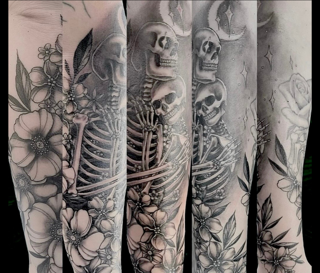 Full-sleeve tattoo design with skeletons, flowers, and leaves, moon and stars by Channy, tattoo artist at Sundog Studios at Airdrie Alberta