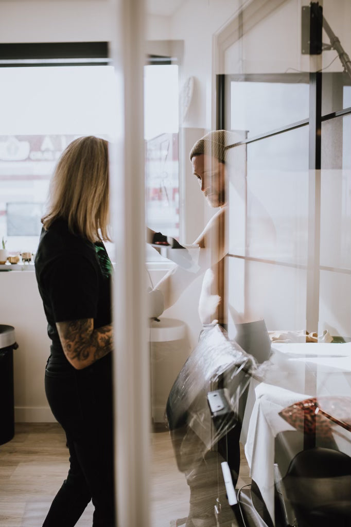 Tattoo artist preparing client in a private station at Sundog Studios tattoo shop in Airdrie