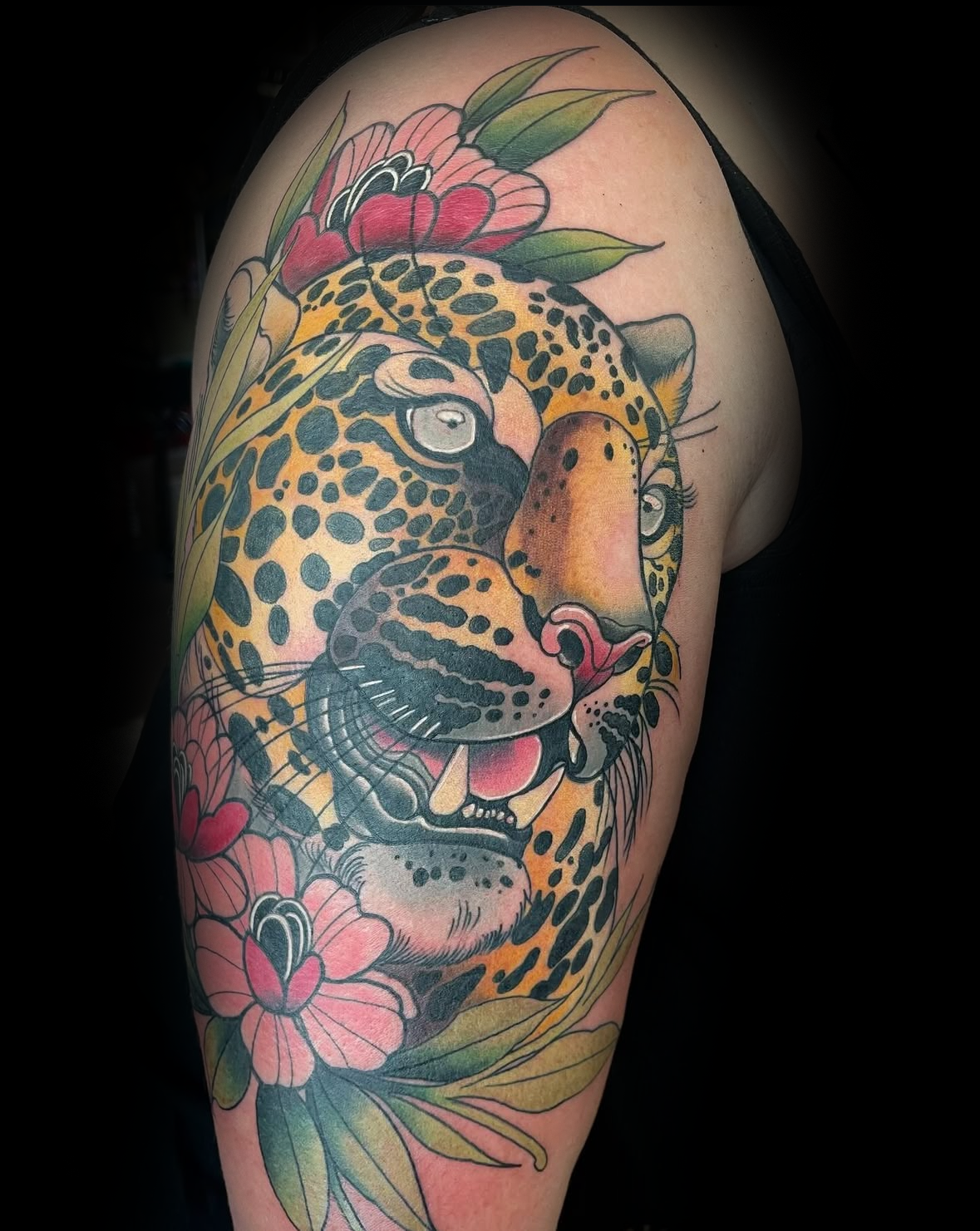 Colorful tattoo of a leopard with flowers on a person's arm by Rob Adams, tattoo artist at Sundog Studios in Airdrie Alberta