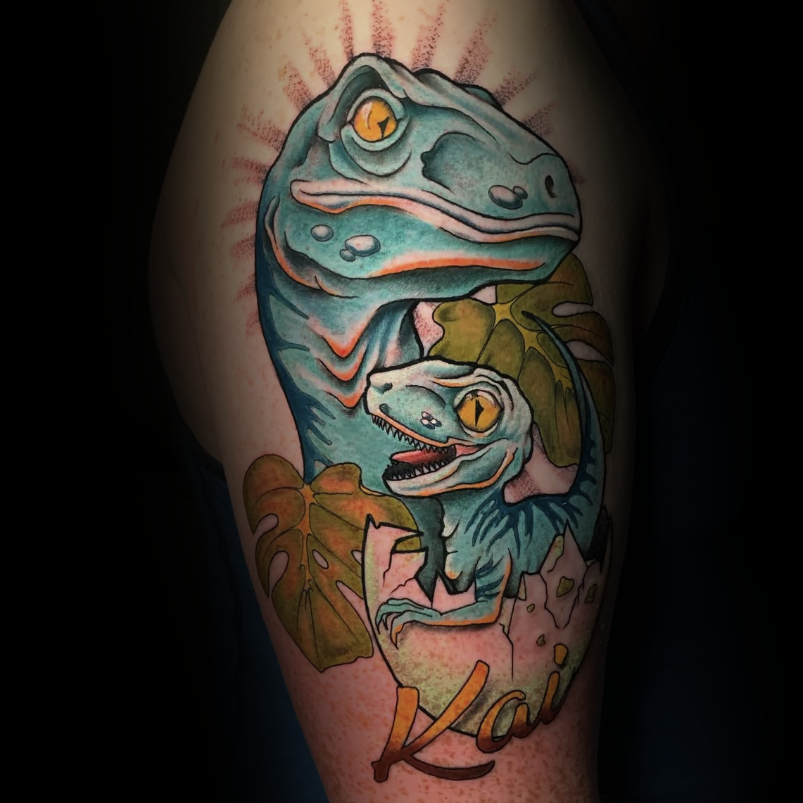Colour tattoo of two dinosaurs with leaves and cracked egg by Dominic, tattoo artist at Sundog Studios in Airdrie Alberta