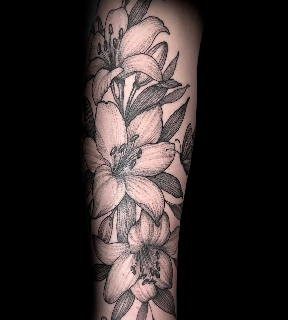 Fine line lily forearm tattoo in black and grey by Sundog Studios tattoo artists in Airdrie Alberta