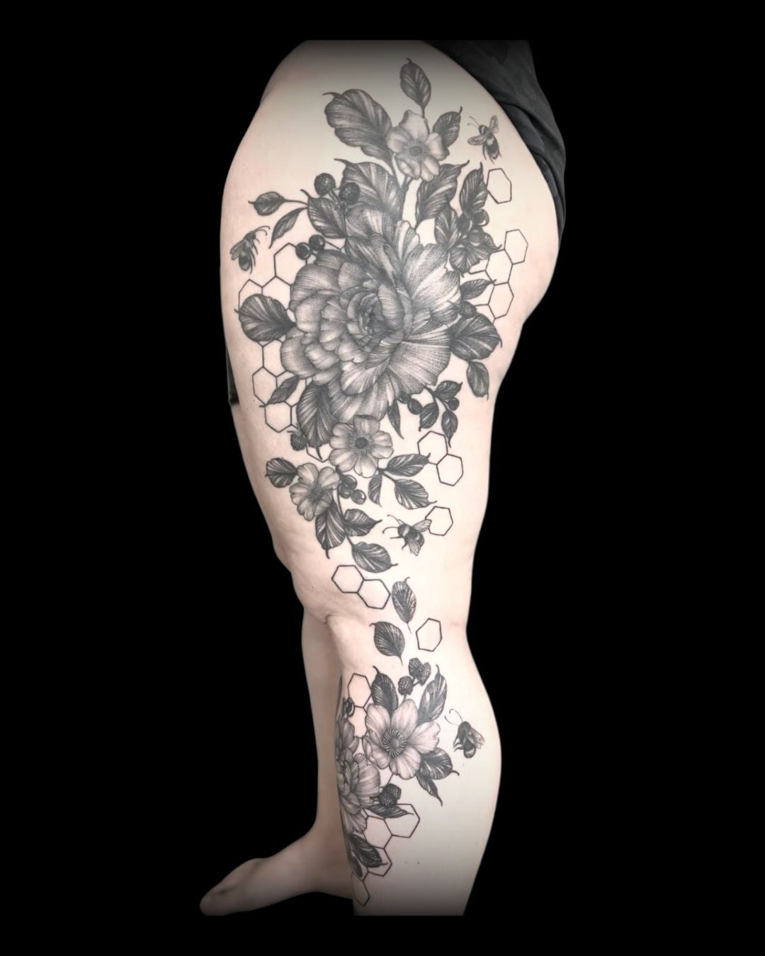 floral and honeycomb full leg tattoo design with botanical elements and bees by Mahala at Sundog Studios in Airdrie, Alberta