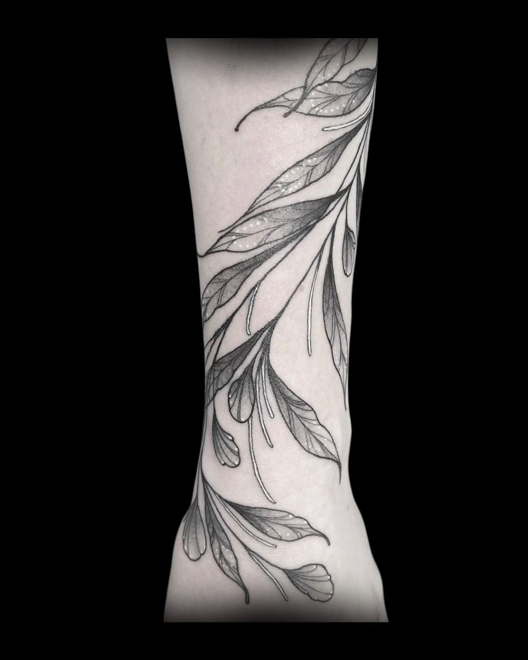 Tattoo of leaf designs on a person's arm by Mahala, tattoo artist at Sundog Studios in Airdrie Alberta