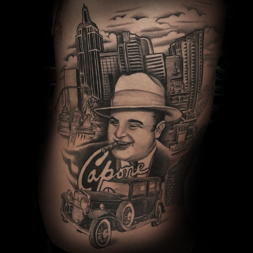 Tattoo of a man with a hat and car, set against a cityscape background by Dominic, tattoo artist at Sundog Studios in Airdrie Alberta