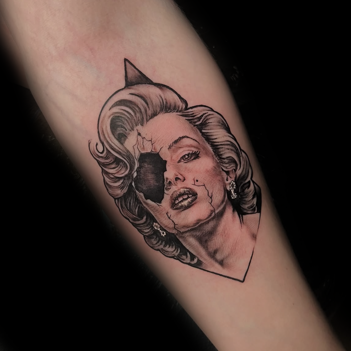 Tattoo of a stylized Marilyn Monroe's face with a black eye by Dominic, tattoo artist at Sundog Studios in Airdrie Alberta