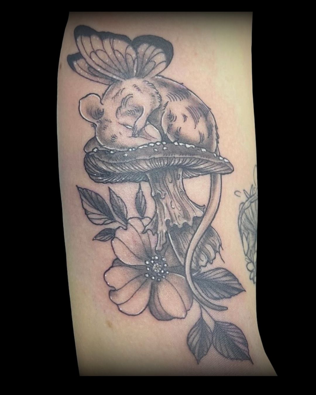 Tattoo of a mouse on with a wing butterfly on top of a mushroom and flower by Channy, tattoo artist at Sundog Studios in Airdrie Alberta