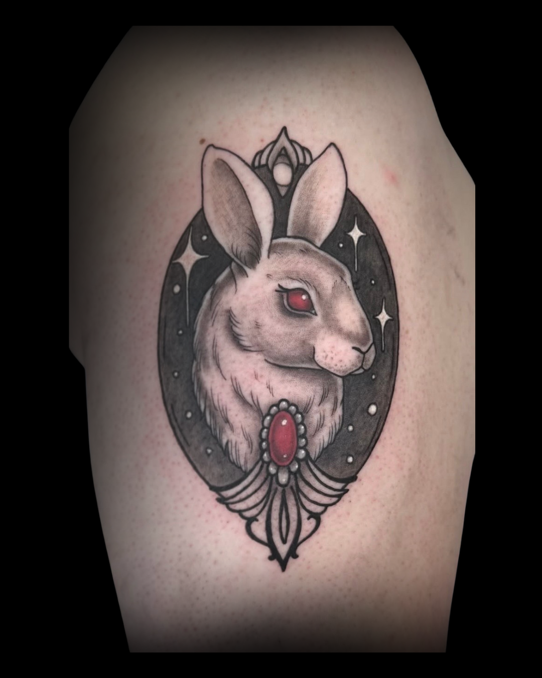 Tattoo of a rabbit with red eyes and decorative elements on a person's arm by Channy, tattoo artist at Sundog Studios at Airdrie Alberta