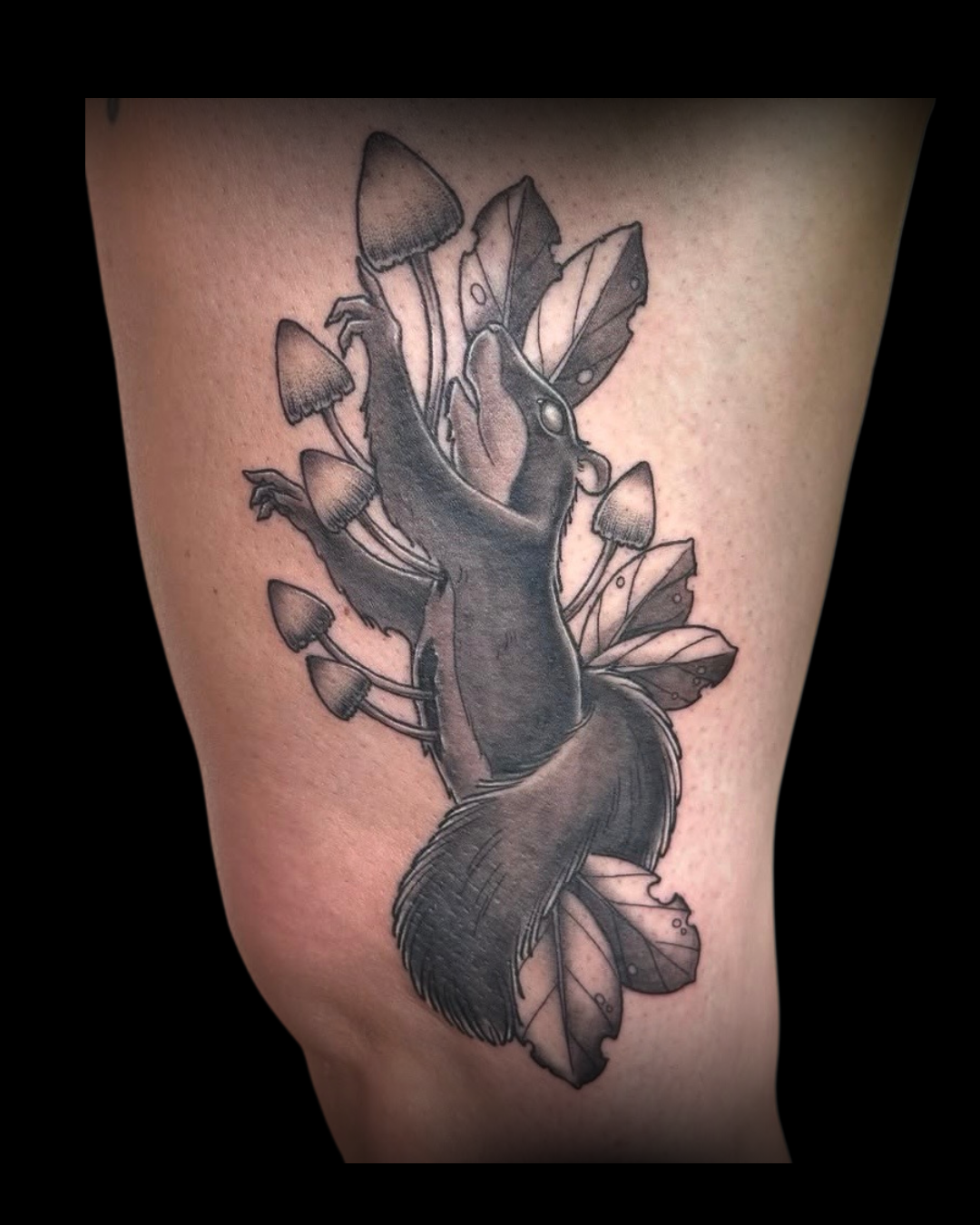 Black and gray tattoo of a squirrel with mushrooms on a person's thigh by Channy, tattoo artist at Sundog Studios in Airdrie Alberta