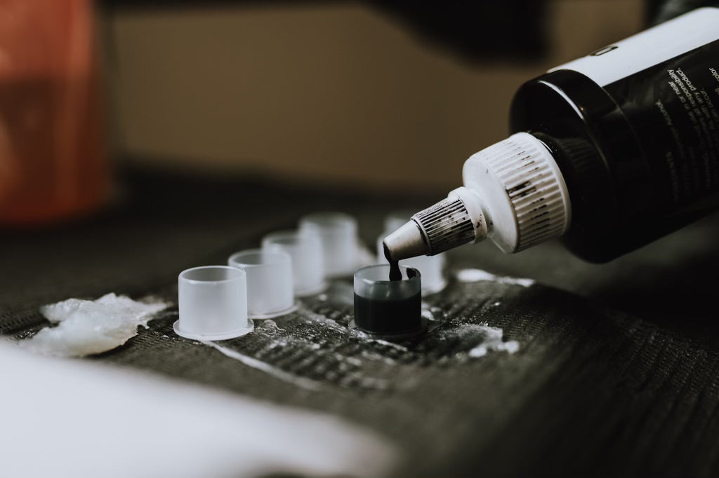 tattoo ink being poured into ink caps at Sundog Studios tattoo shop in Airdrie Alberta