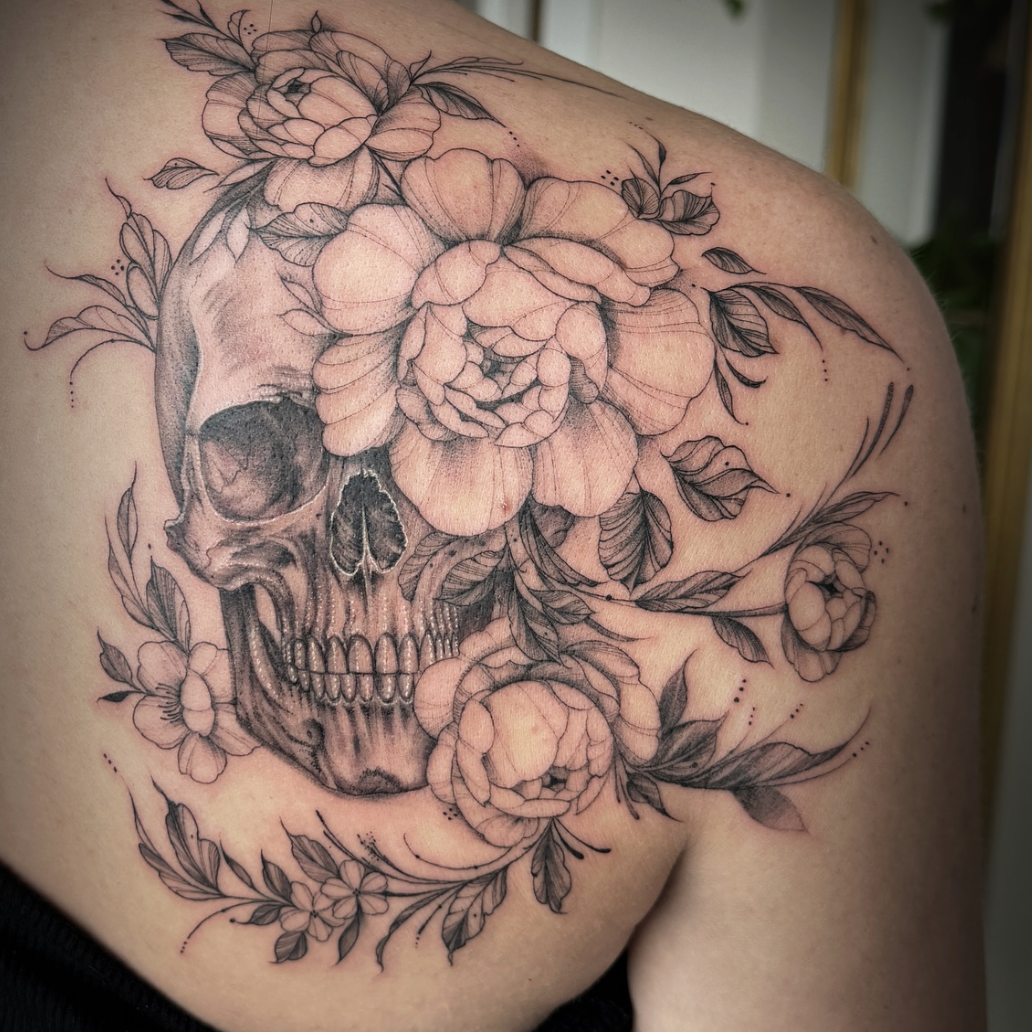 Skull and floral tattoo on a person's shoulder credit to Yvonne Koprnicky